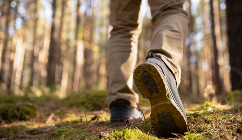 Un bărbat tânăr care se plimbă într-o pădure