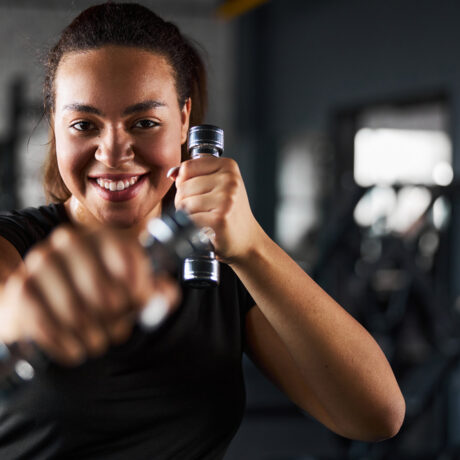 O femeie tânără care practică Tae Bo în sala de fitness