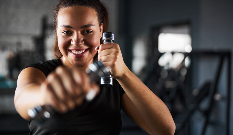 O femeie tânără care practică Tae Bo în sala de fitness