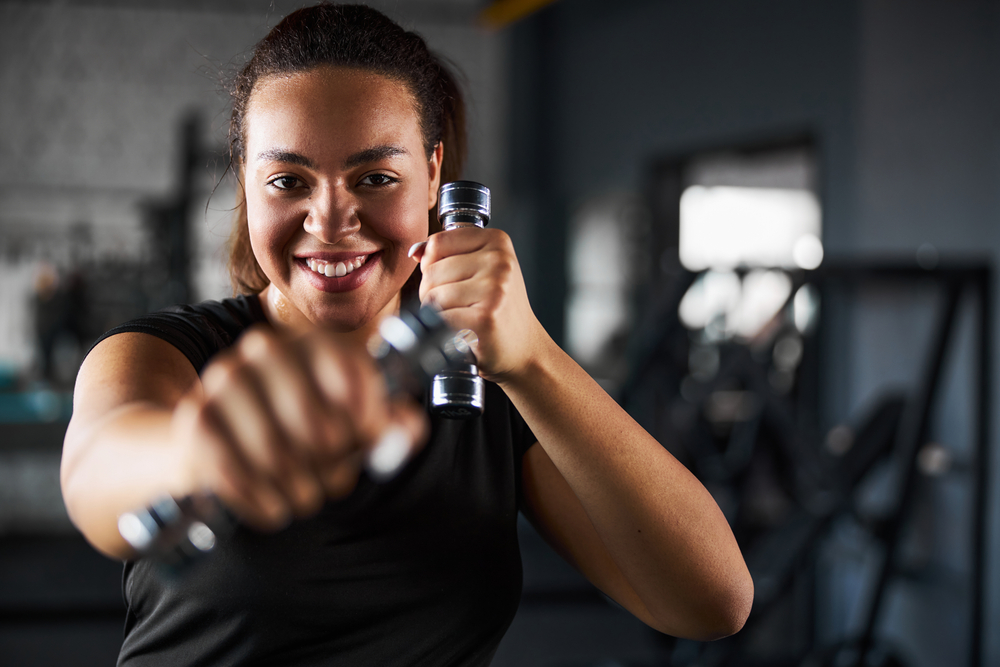 O femeie tânără care practică Tae Bo în sala de fitness