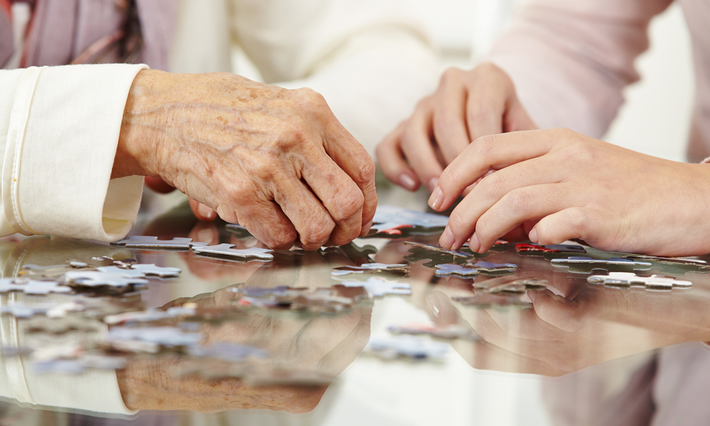 O femeie tânără și o femeie aflată la o vârstă mai înaintată rezolvă un puzzle