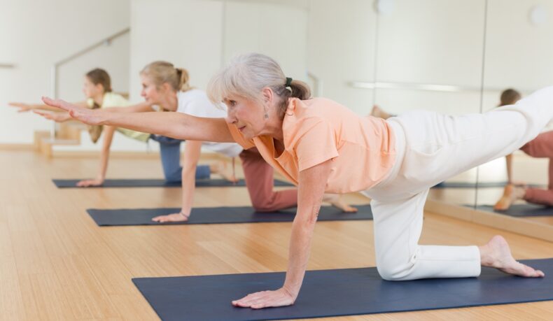 Mai multe femei aflate la o vârstă mai înaintată care fac exerciții de stretching