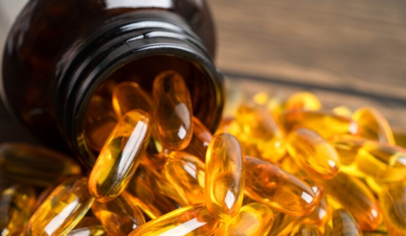 Mai multe capsule cu acizi grași Omega 3 și un borcan