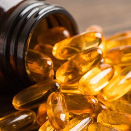 Un borcan din care se varsă capsule cu acizi grași Omega 3