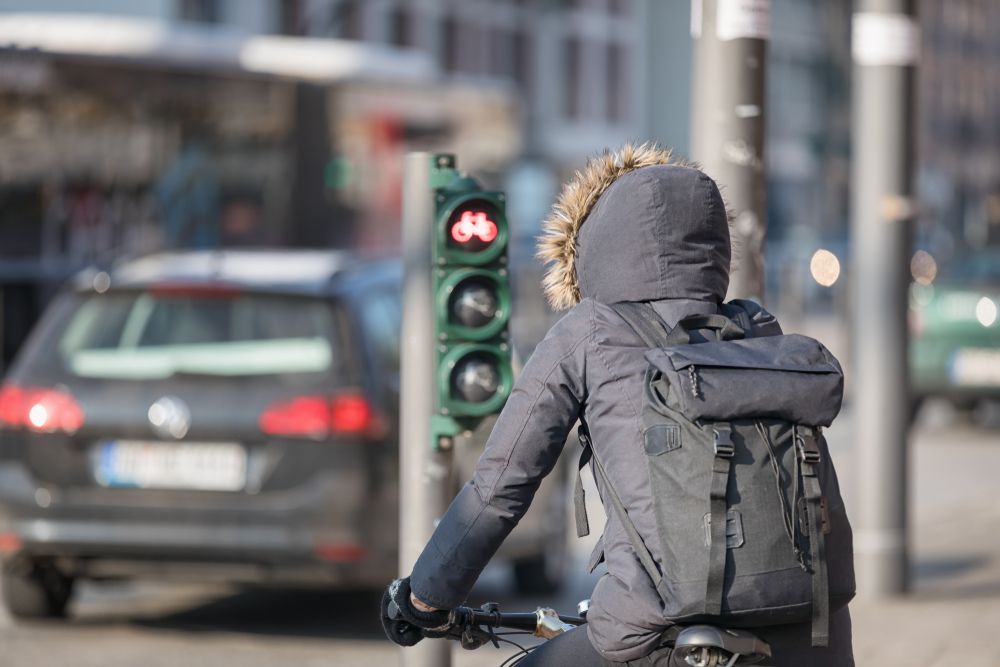 O femeie care merge cu bicicleta pe stradă