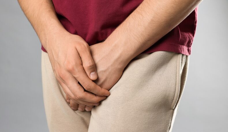 un bărbat cu mâinile în zona inghinală, sugestiv pentru boli cu transmitere sexuală